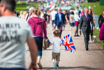 选择聚焦摄影的男孩拿着英国国旗走在道路挤满了人
